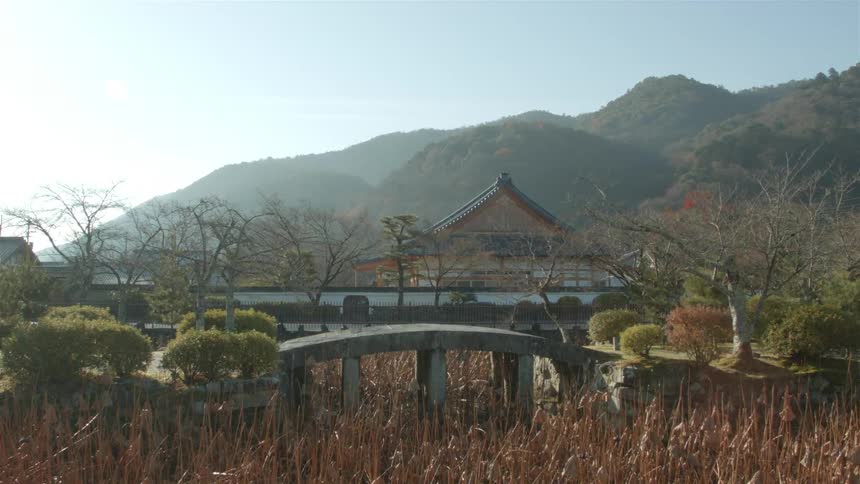 A small house is surrounded by hills covered with green
