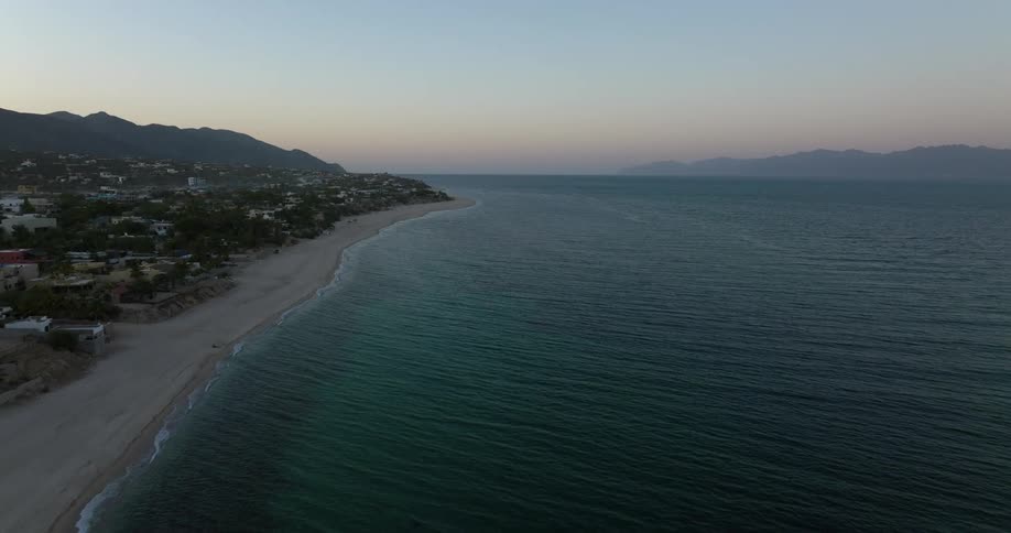 Aerial view of a beach during sun set is displayed