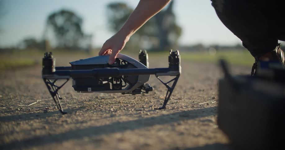A man places a drone on the ground