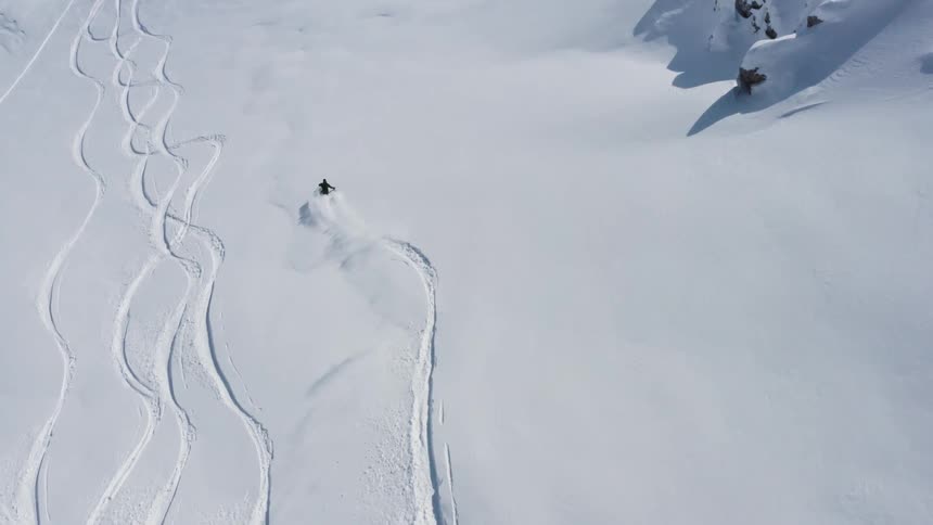 A group of people are skiing down a mountain in winter