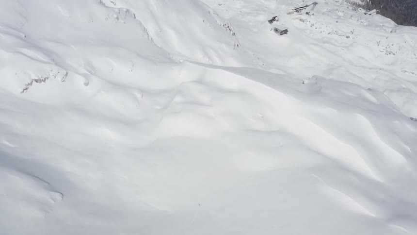 Aerial view of snow covered mountains is displayed