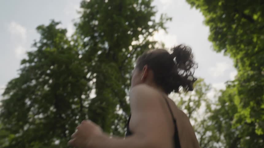 A young woman jogging outside on a sunny summer day