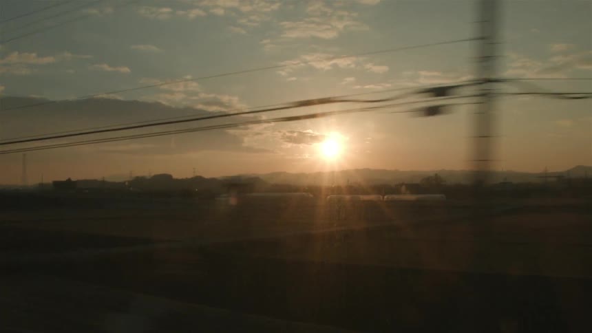 Traveling down a road near large fields at sunset