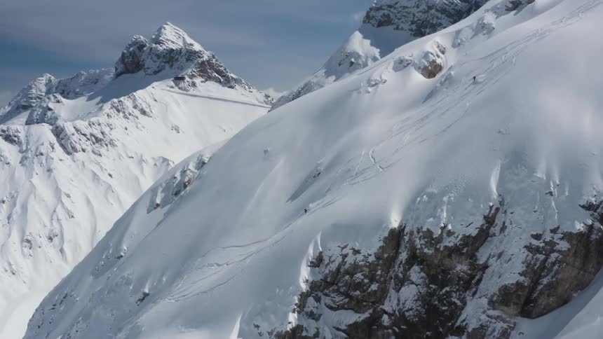 A person is skiing down a mountain slope during winter