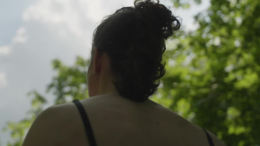 A woman jogging outside on a path near trees