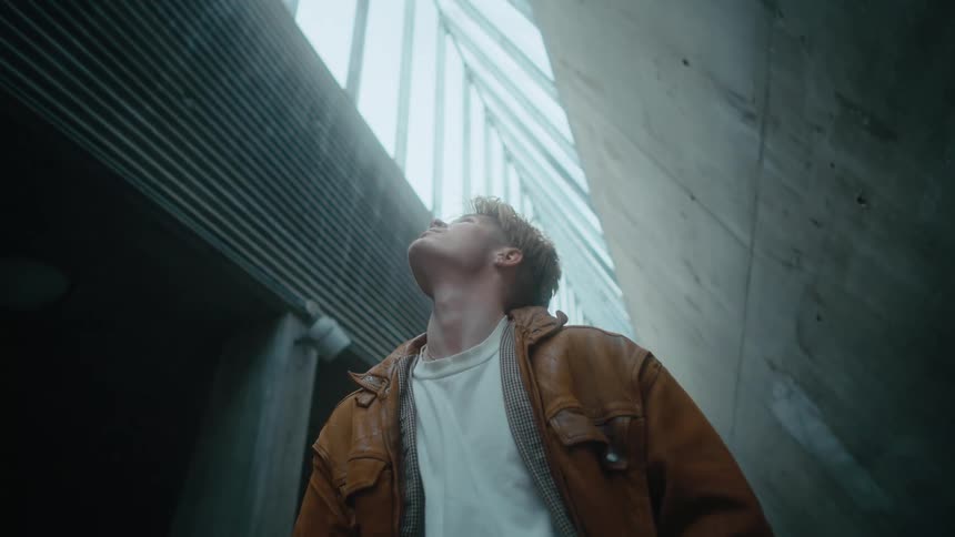 Man stands looking up at pointed glass ceiling