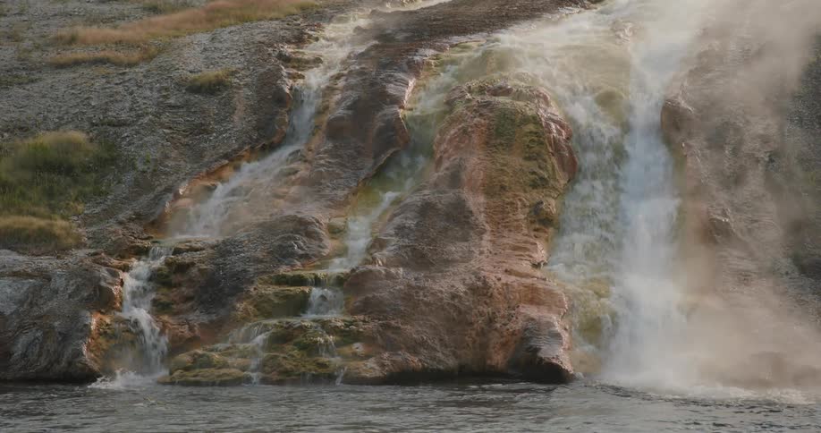 Water is splashing down a waterfall into a river