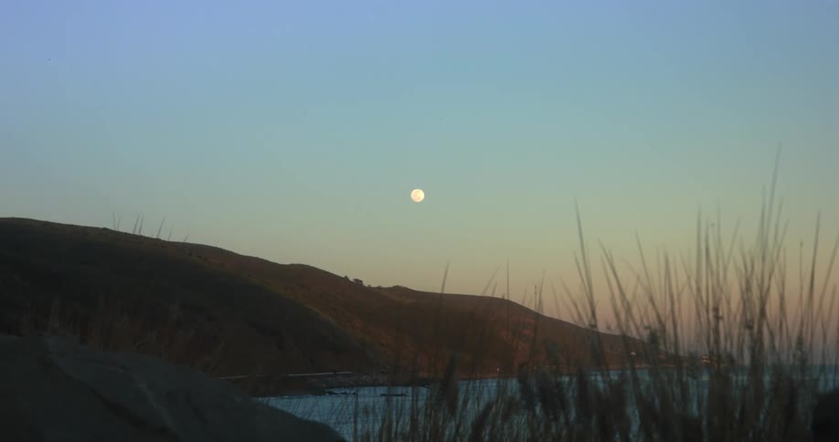 The sun is setting in the horizon of a landscape