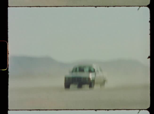 A car is driving really fast outside in the middle of the day