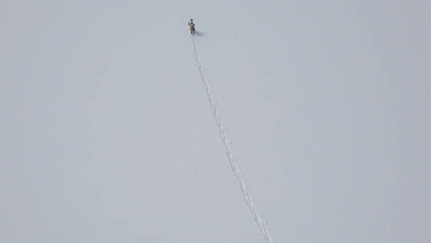 A single set of tracks in undisturbed snow made by a lone cross country skier and his poles
