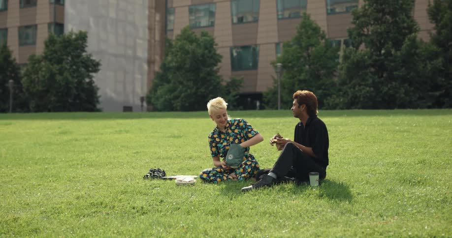 Man and woman are eating lunch in a grassland area