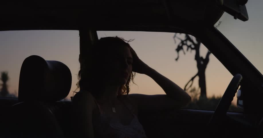A woman is relaxing and chilling in her car