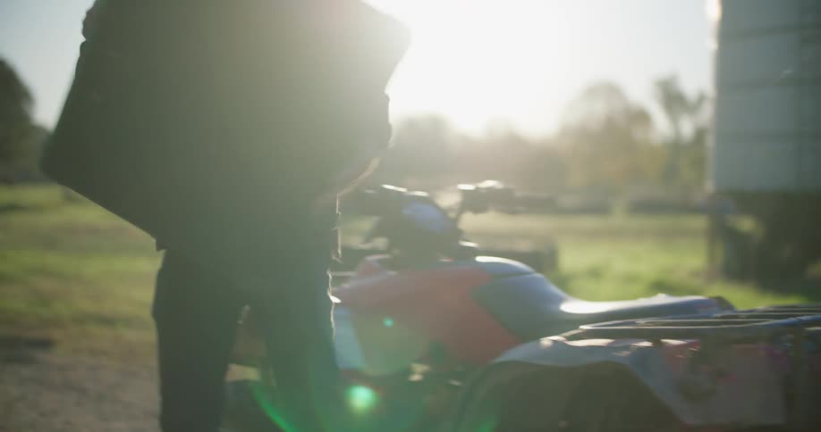 Man steps off four wheeler removing case to set on the ground in the road