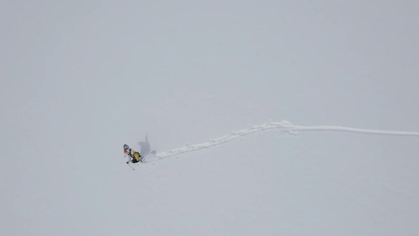 A lone person hiking across a snowy expanse in winter