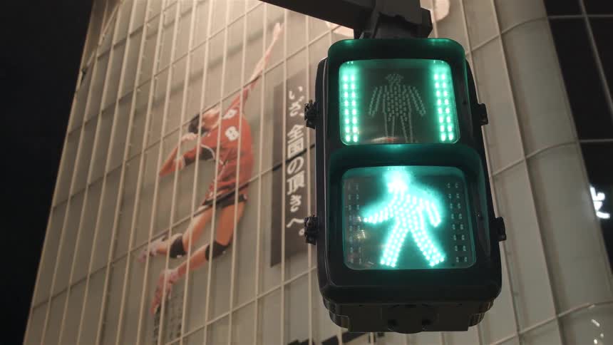 A traffic light in front of a building changes