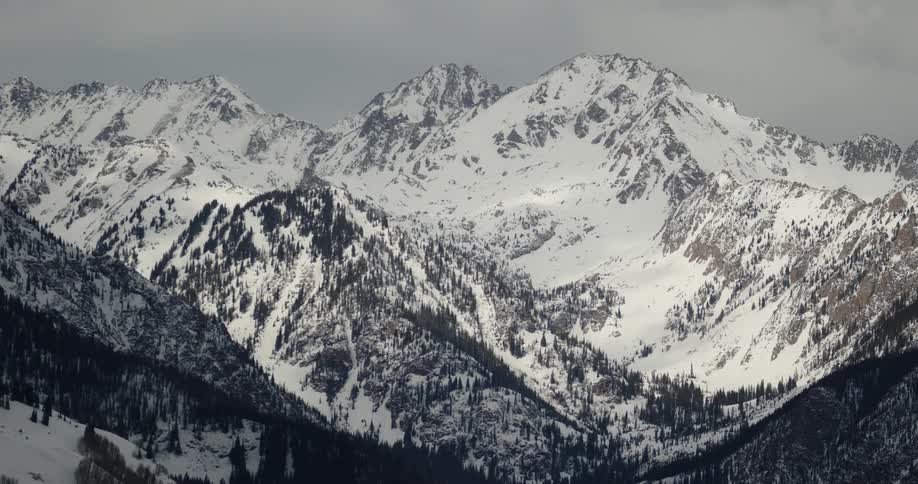 Snow dusted rocky mountain ridge slopes and valley
