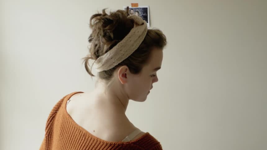 A woman tapes photos on the wall