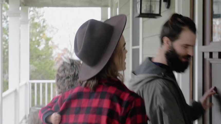 A couple with a baby enter a home