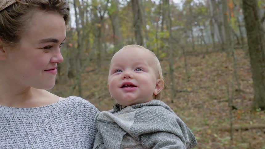 A woman is holding a smiling baby