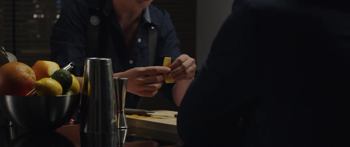 A female bartender preparing a drink for a male patron