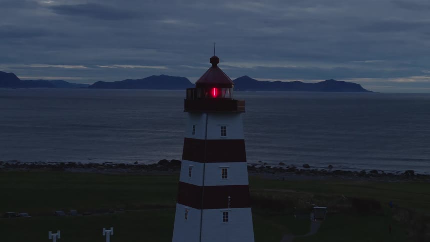 Aerail view of lighthouse neard the coast at dusk