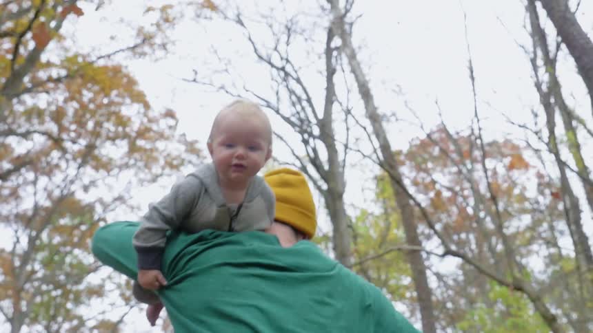 A man runs with a baby over his shoulder