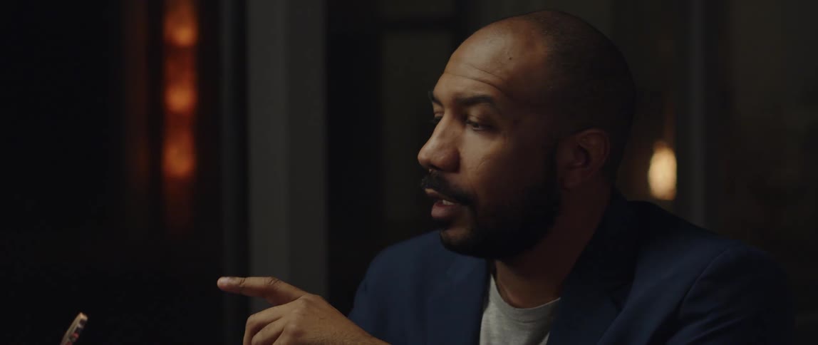 A man is sitting in a room and talking to someone