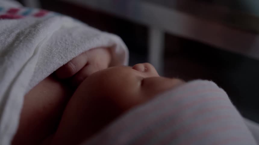 A newborn infant is sleeping in a crib