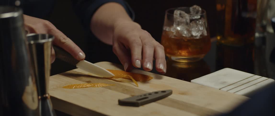 A person is cutting food on the cutting board with a knife