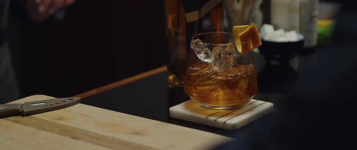 Woman serves man a cocktail and he toasts her