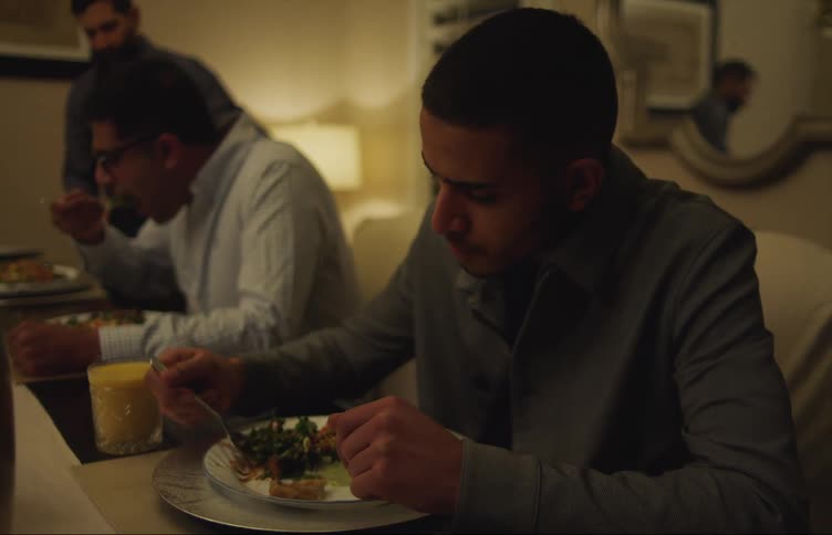 Three men are eating dinner together in their dining room