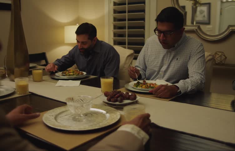 A family chats while eating dinner at home