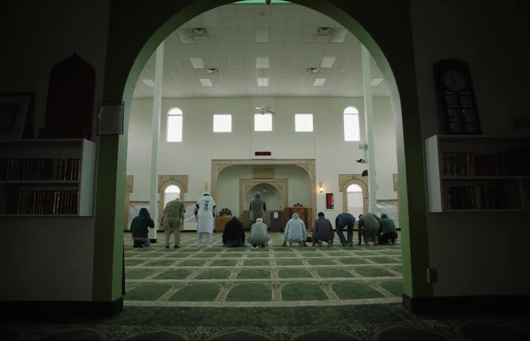 A group of men are bowing down on the floor in a monastery or church