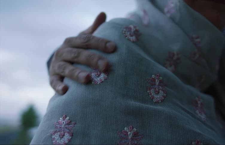 A person rubbing anothers shoulder outside