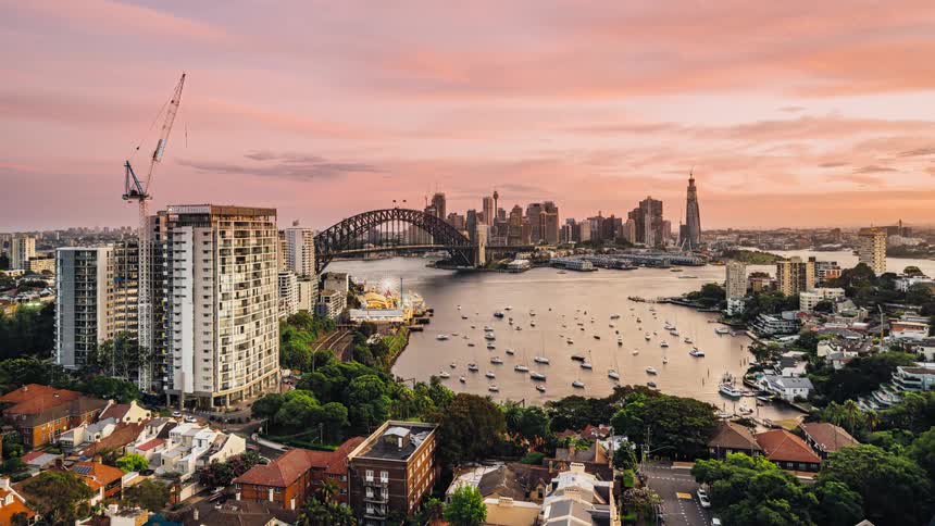 Boats sail in a cove near apartment buildings in a city