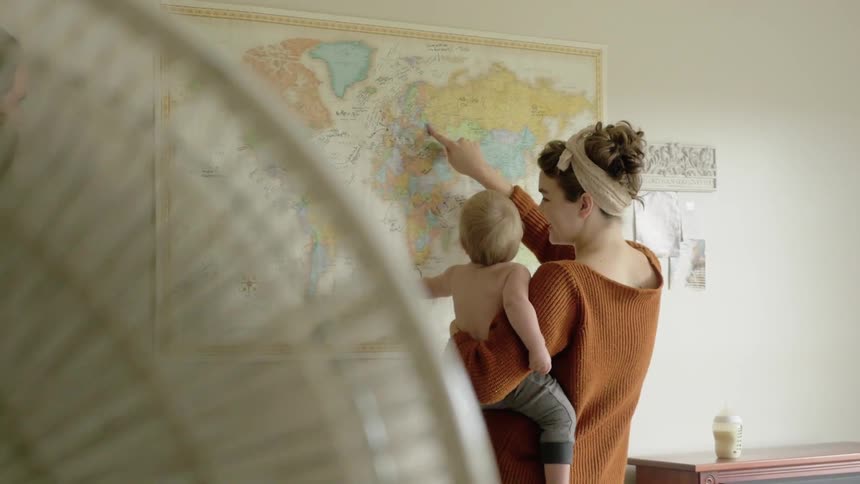 A woman points to areas of the map with a baby
