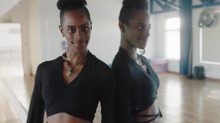 A black woman is dancing and smiling in the studio