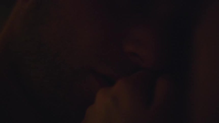 Man kisses a hand in bed