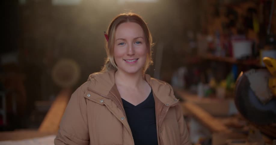 A woman is smiling and standing in a garage