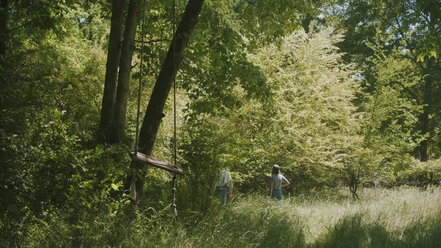 A man and woman hike with their dog through the woods