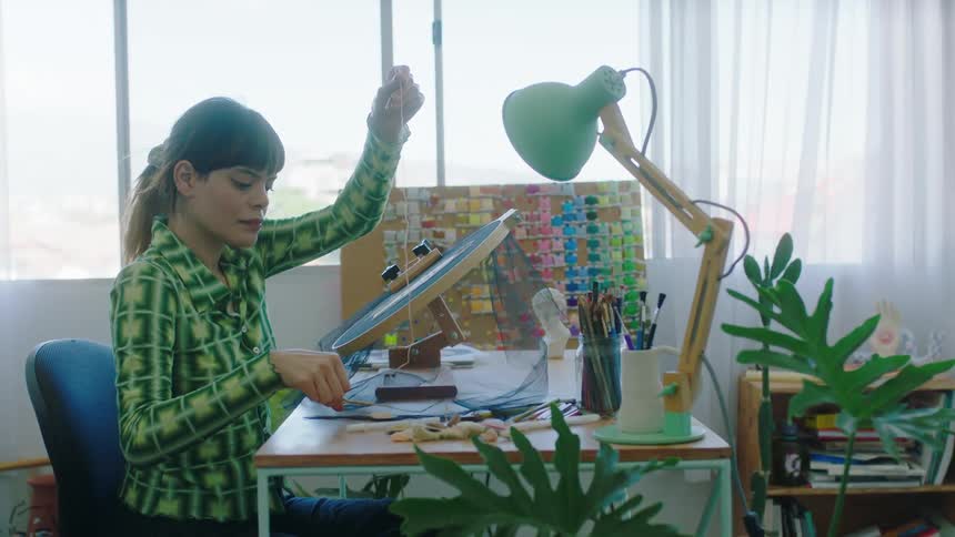 A young woman is working on some crafts indoors