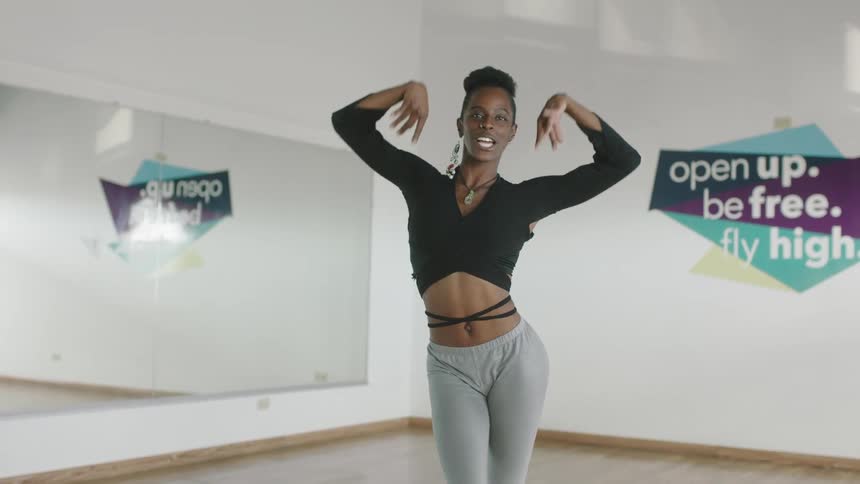 A young woman is dancing and stretching