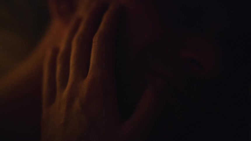 A woman rests her hand on a mans face caressing his cheek