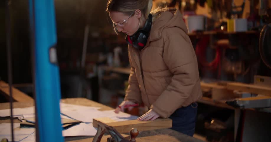 A contractor retrieves a measuring tape while working in a garage