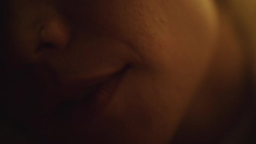 A woman smiles while lying in bed