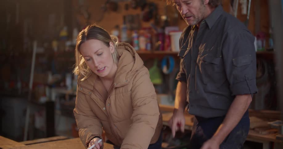 Contractors go over blueprints in a garage