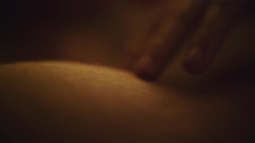 A man runs his fingers over his girlfriends upper arm