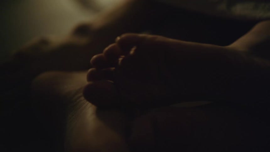 Woman rubbing her uncovered foot against her boyfriends foot in the bed