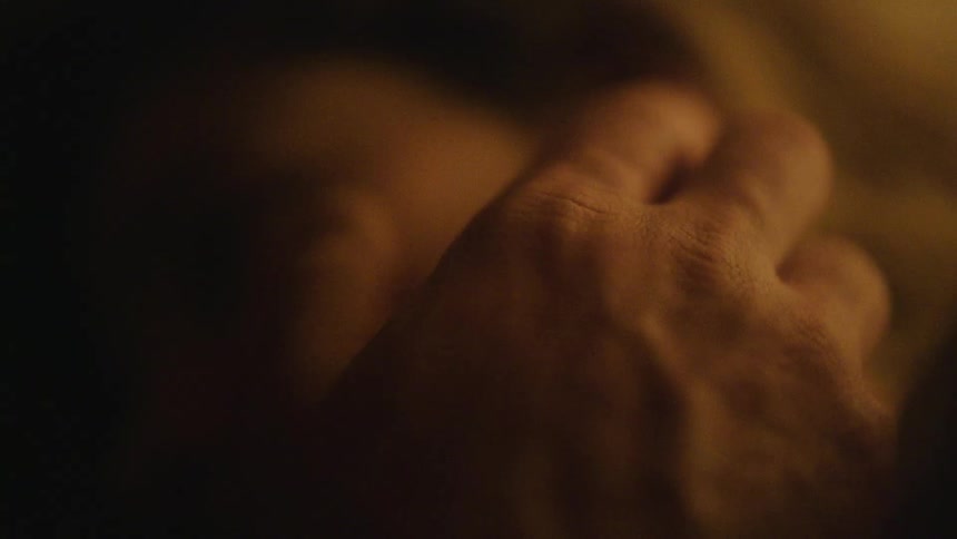 Man caresses cheek of woman who is lying on her side