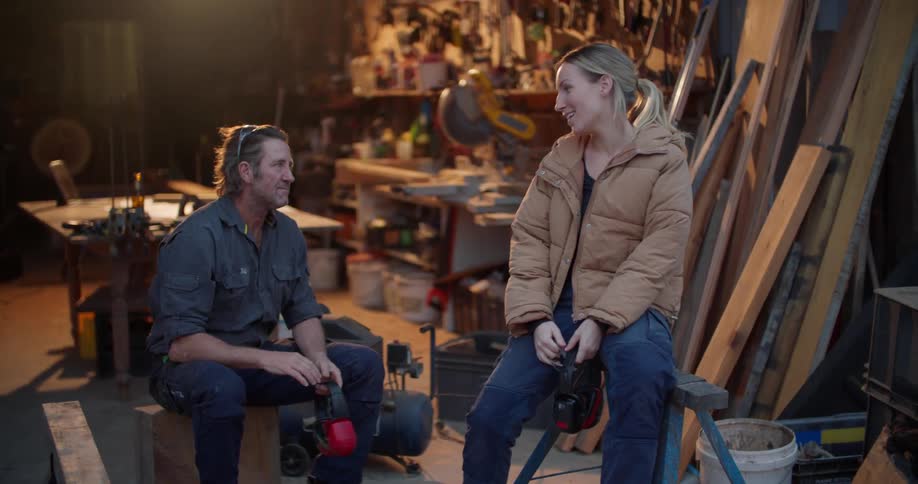 Man and woman are sitting in a garage and having a conversation